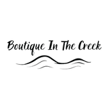 Logo for 'Boutique In The Creek' with stylized text and wave design on a white background