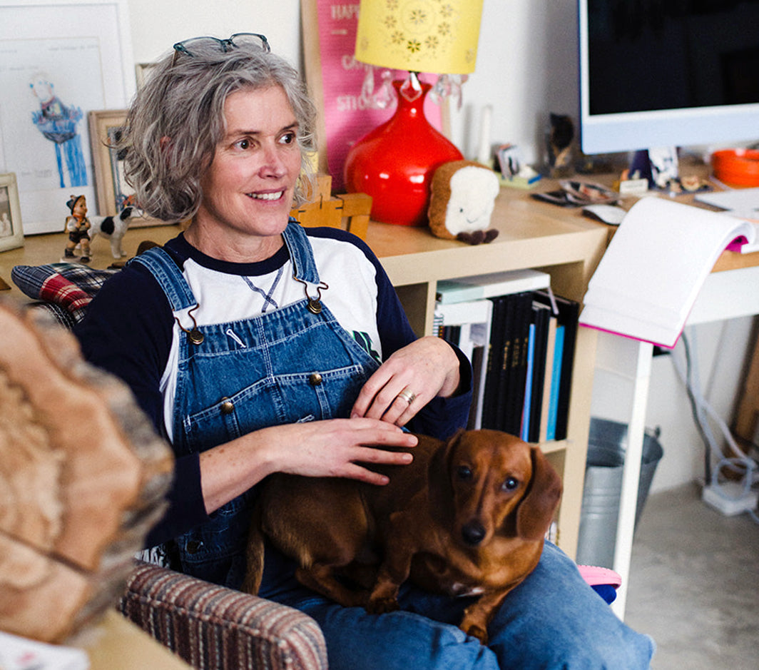 Loo McNulty sitting with a small dog in a home office setting