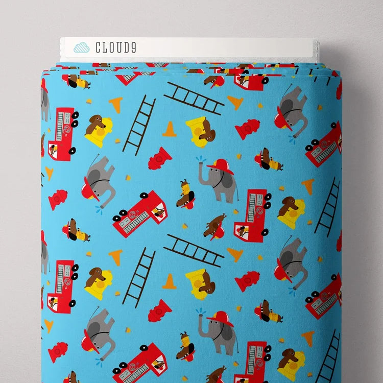 Fabric with fire truck and elephant pattern on a blue background