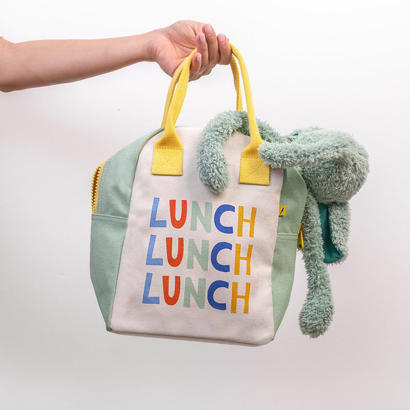 Lunch bag with colorful 'LUNCH' text and plush toy attached on a light background