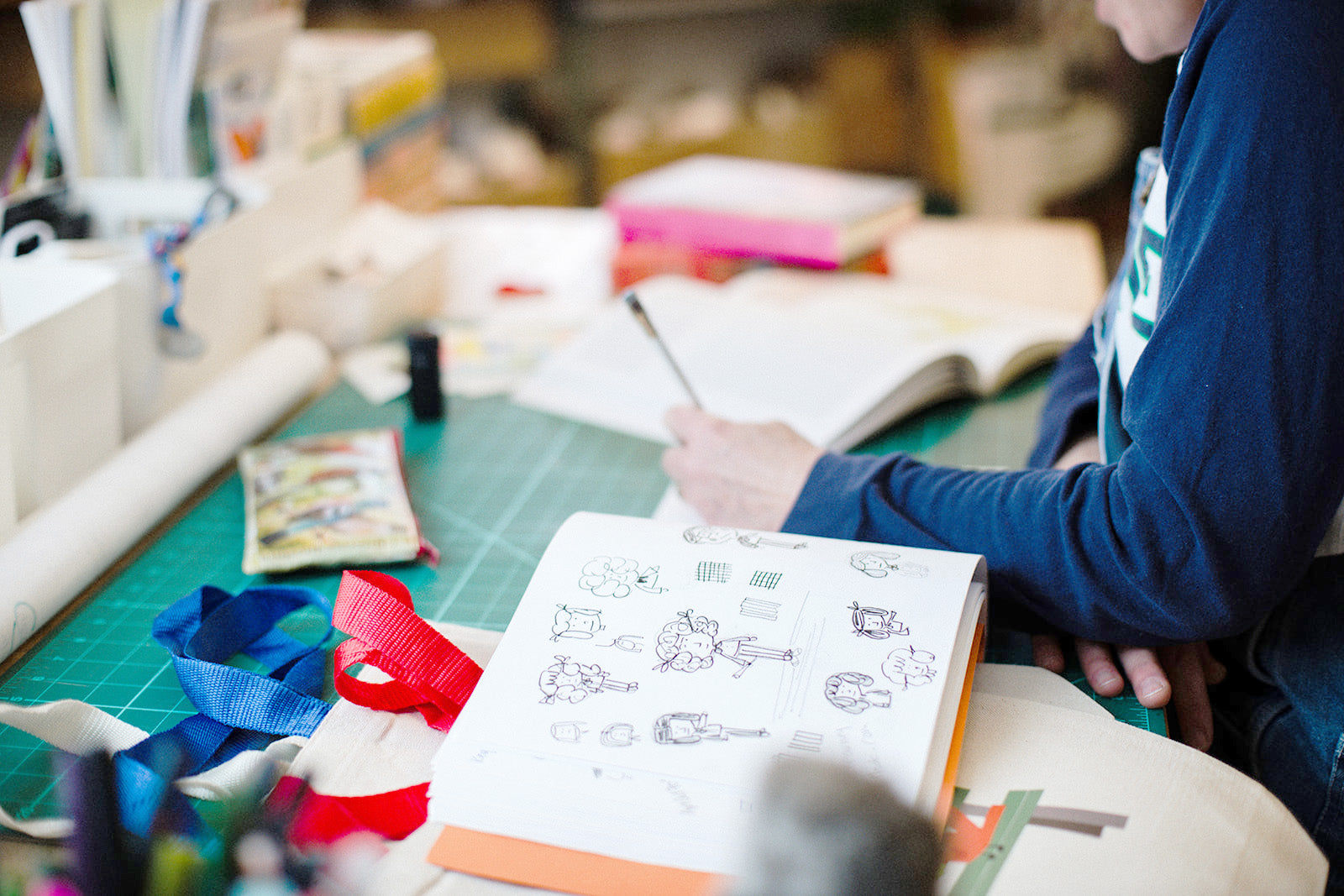 Loo McNulty working on an illustration materials and tools on a table.