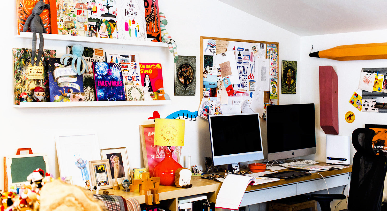 Home office with a desk, computer monitors, and various decorations on the walls.