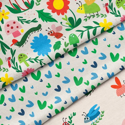 Three pieces of fabric with colorful patterns featuring flowers, caterpillars, and leaves.